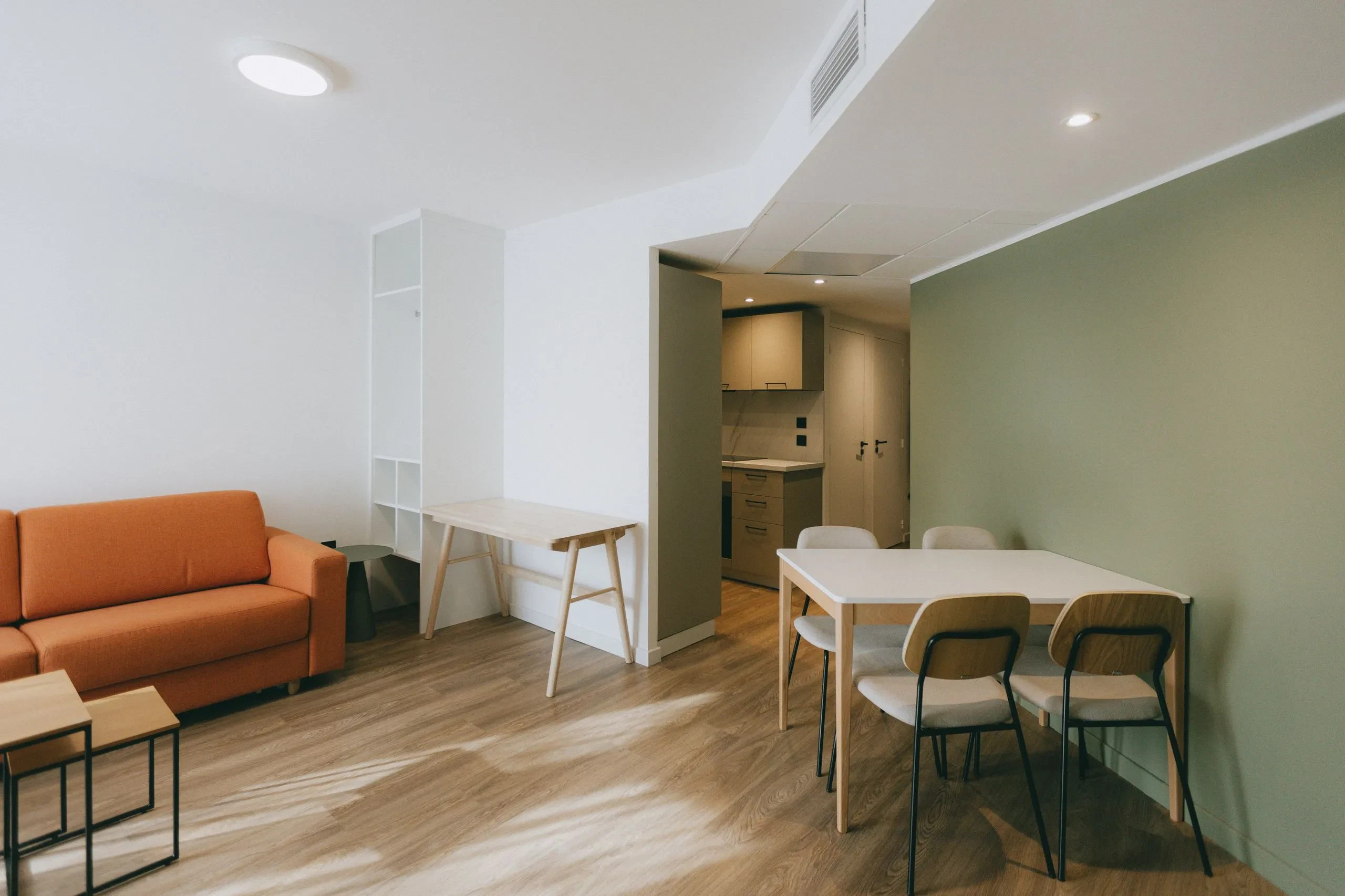 Salon moderne avec canapé orange et table.