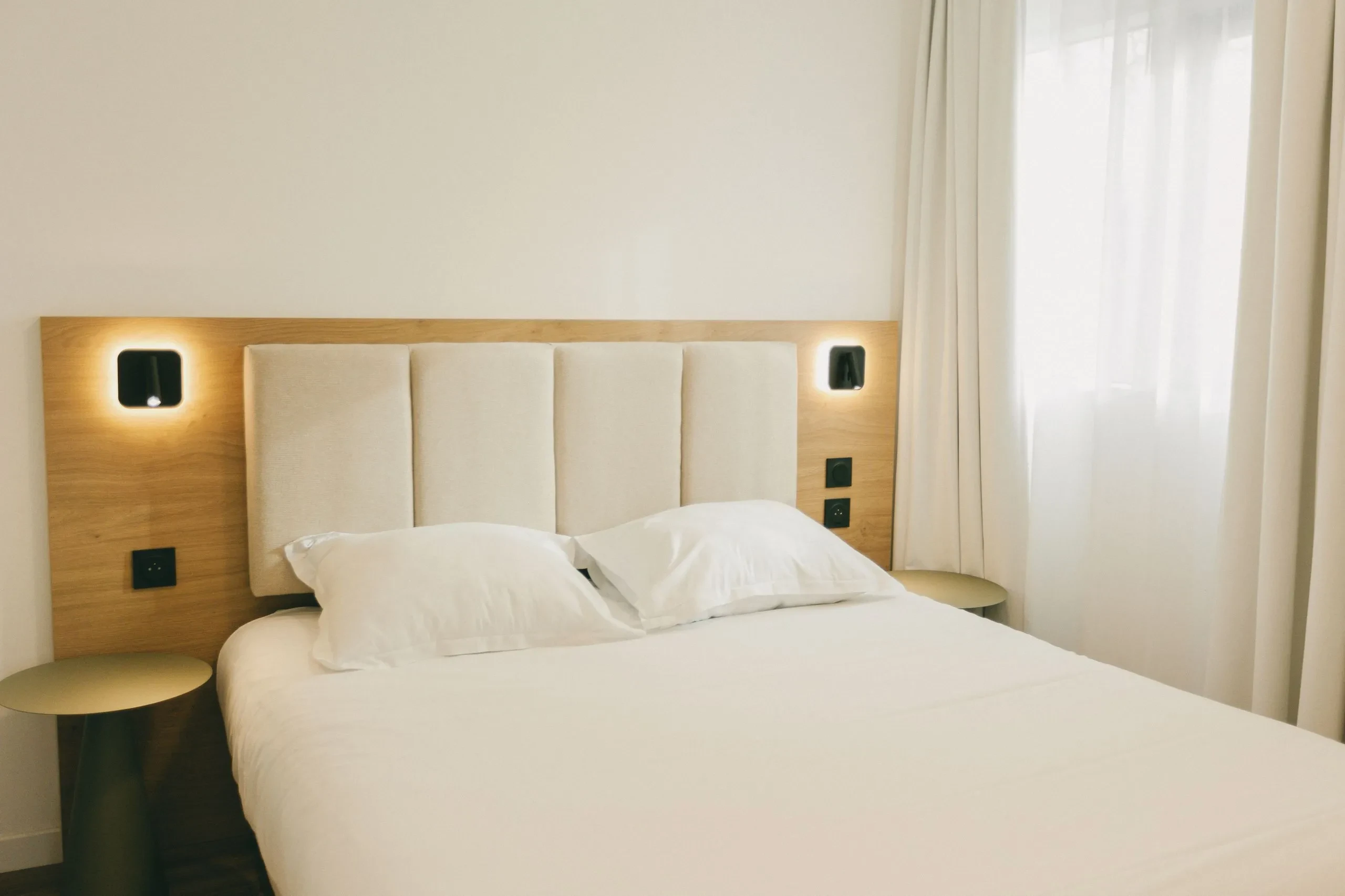 Chambre avec lit double, décor moderne et lumineux.