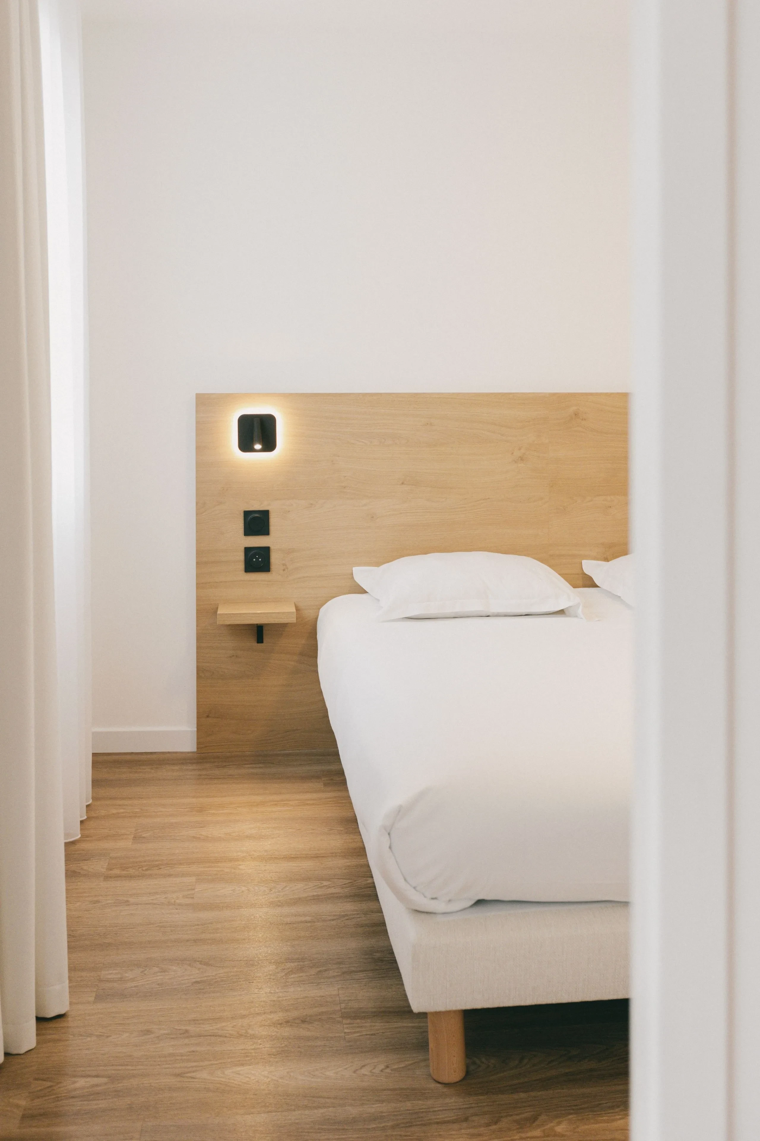 Chambre moderne avec lit et tête de lit éclairée.