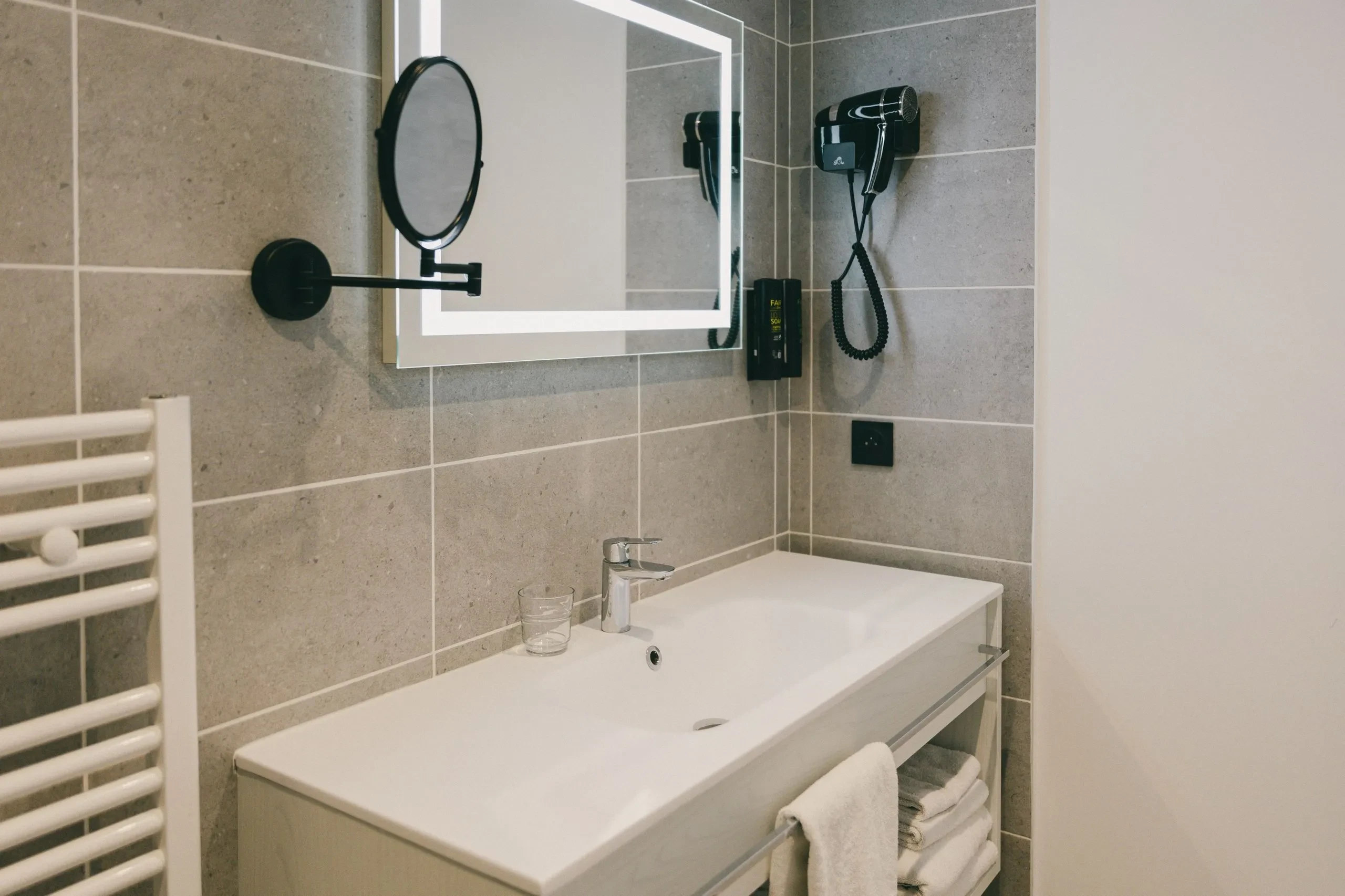 Salle de bain moderne avec miroir et sèche-cheveux