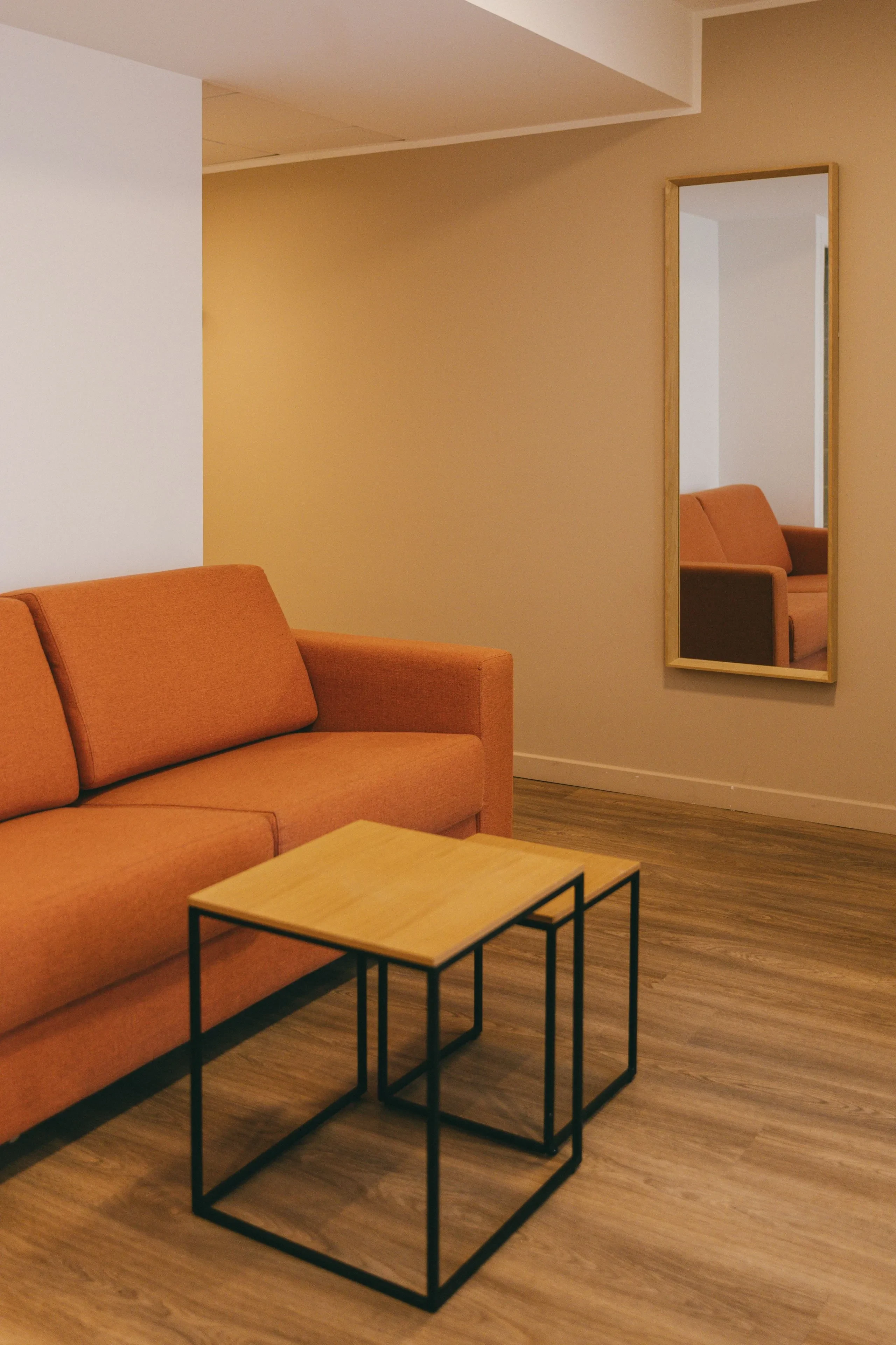 Salon avec canapé orange et miroir