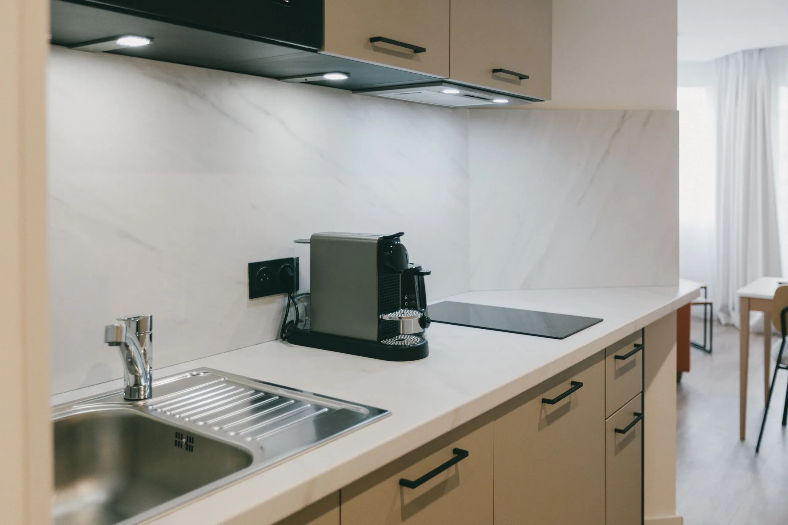 Cuisine moderne avec évier et machine à café.