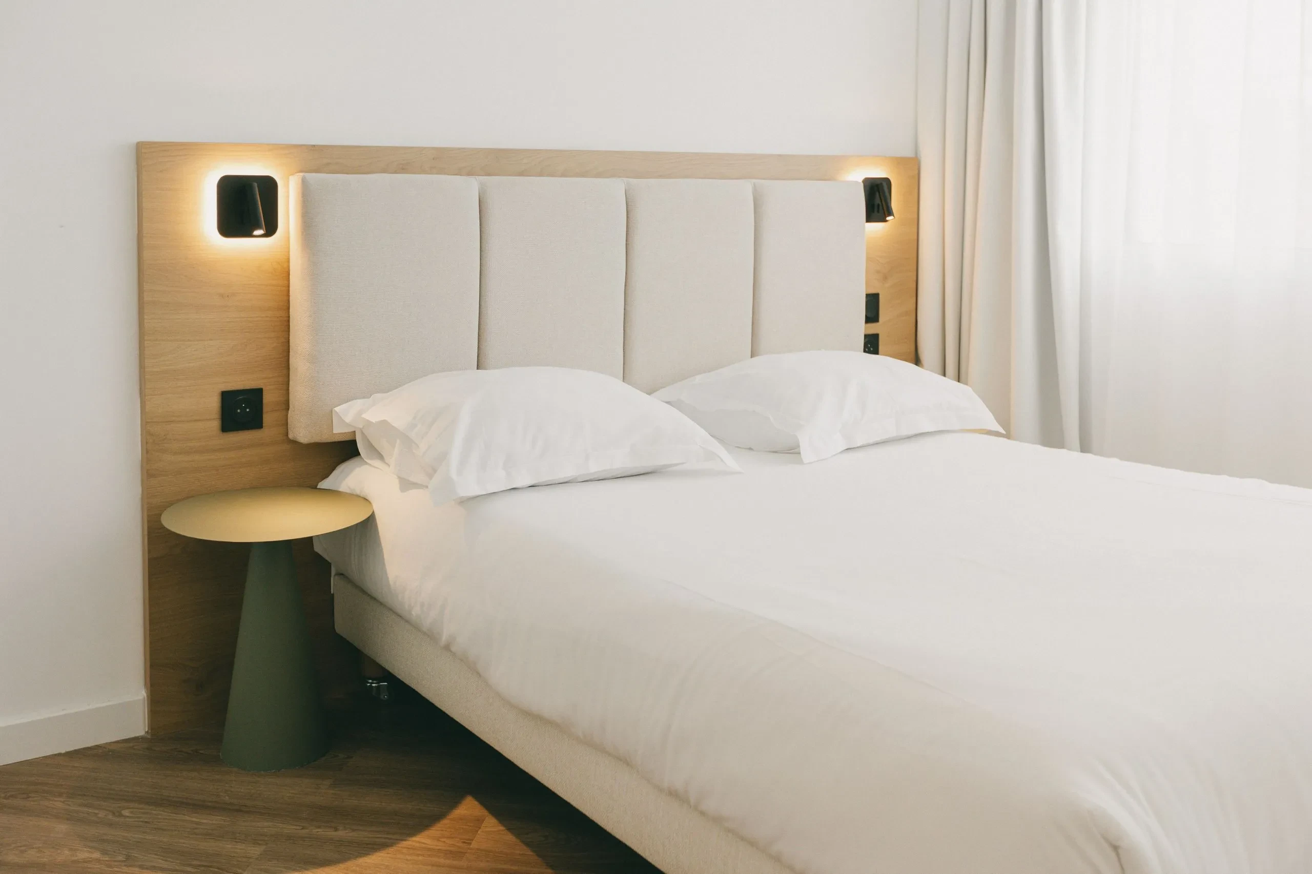 Lit double moderne avec table de chevet.