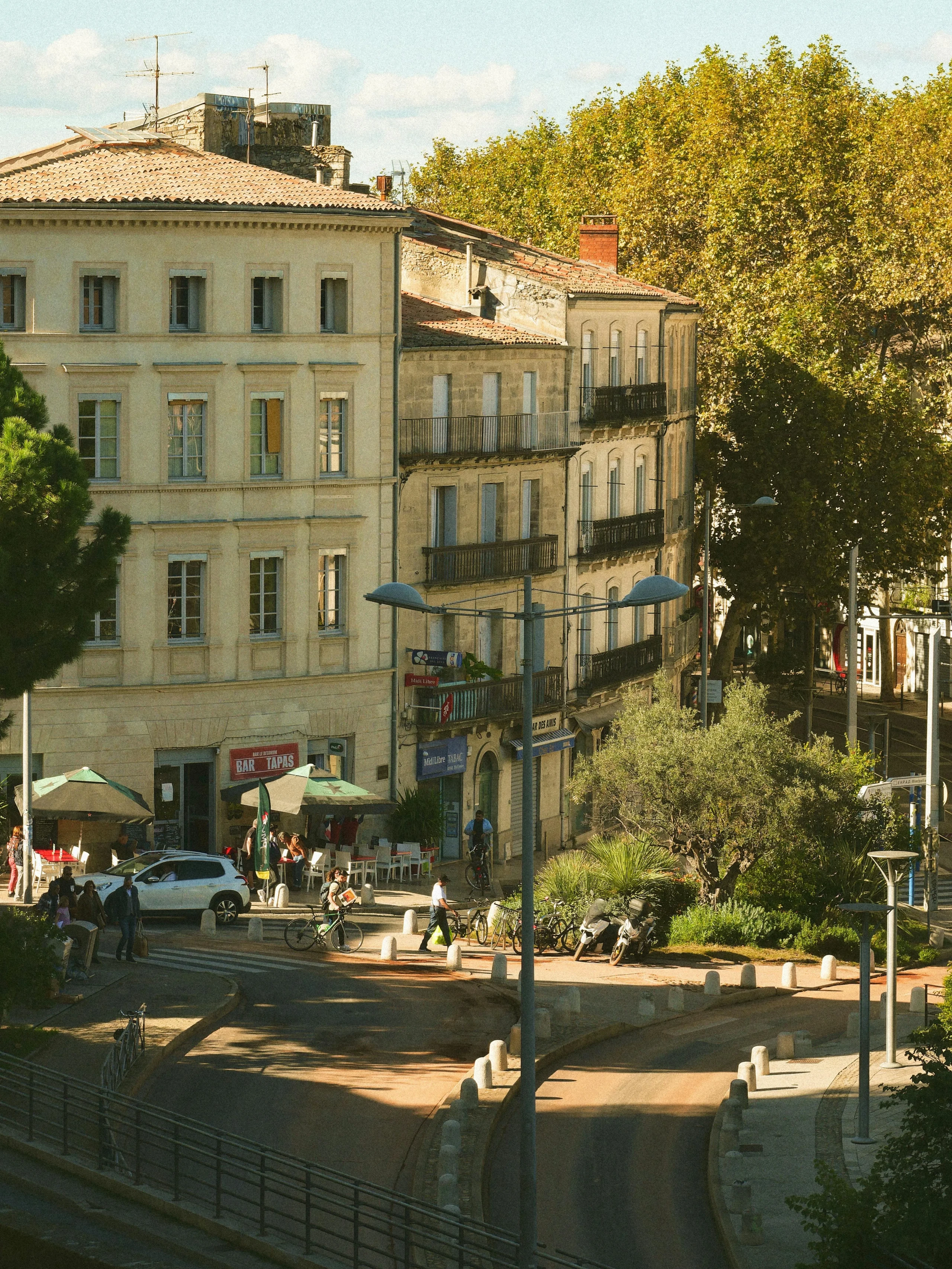 Rue animée avec bâtiments historiques et terrasses.