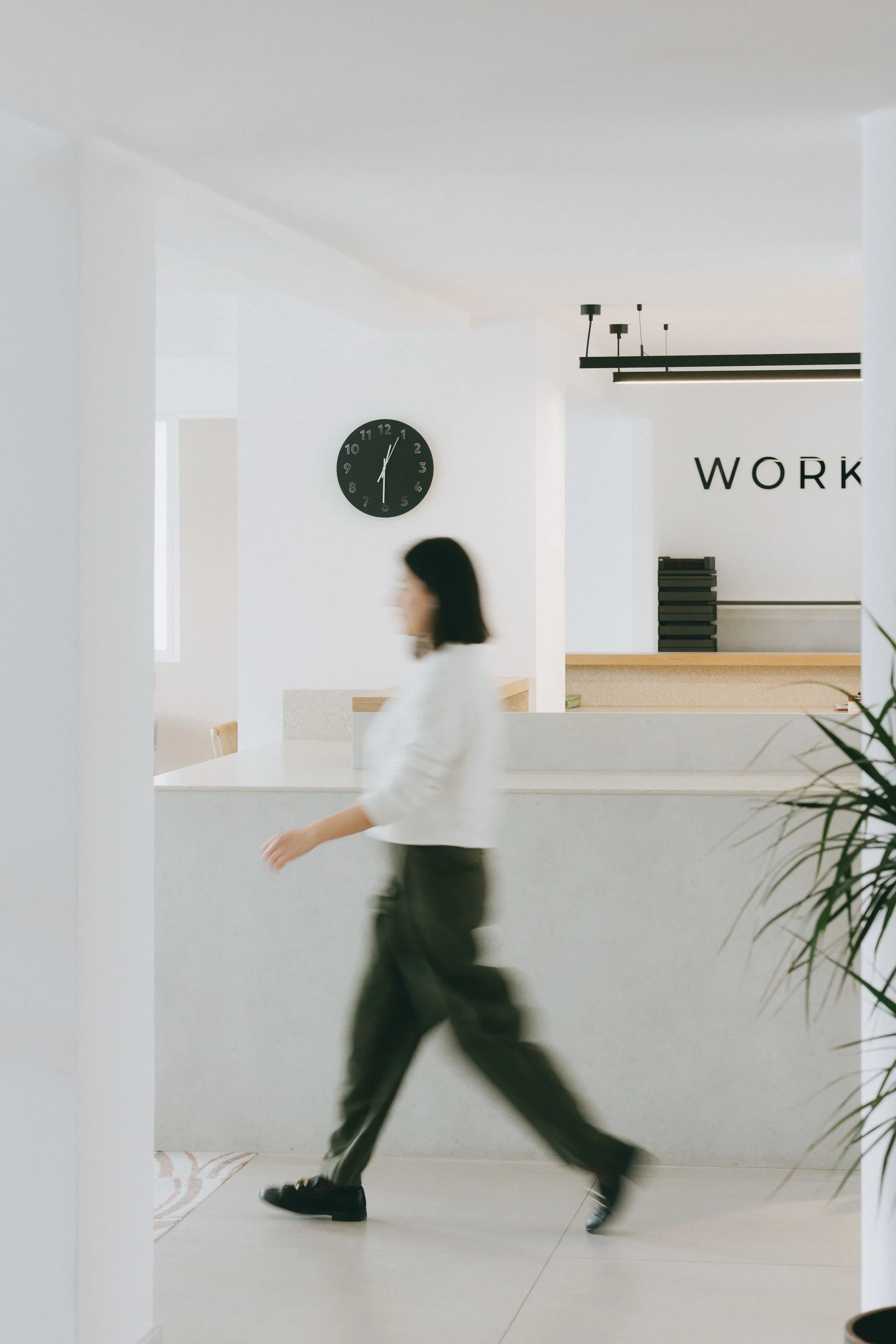 Personne floue marchant dans un bureau moderne.