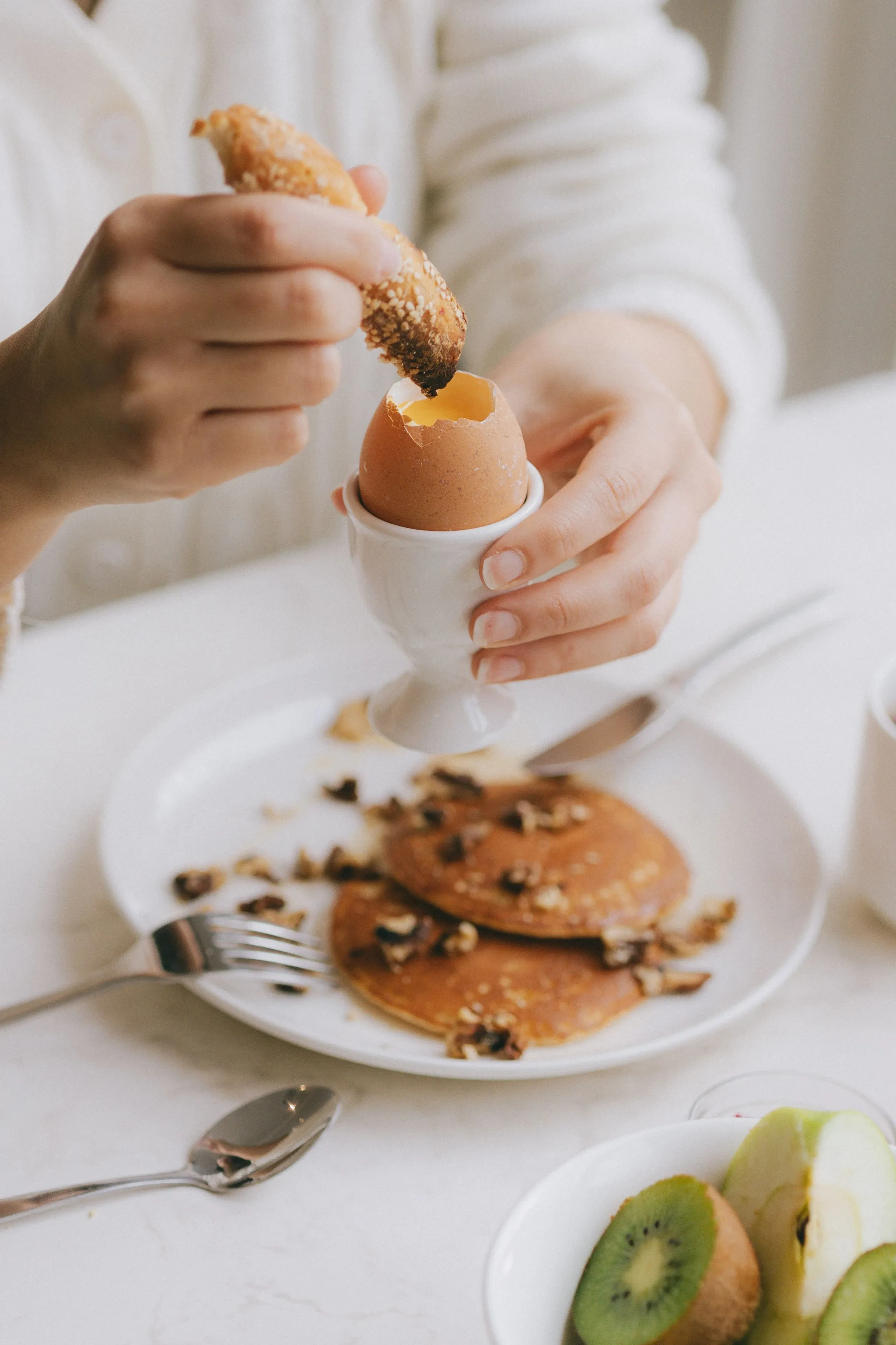 Petit-déjeuner avec œuf à la coque et viennoiserie.