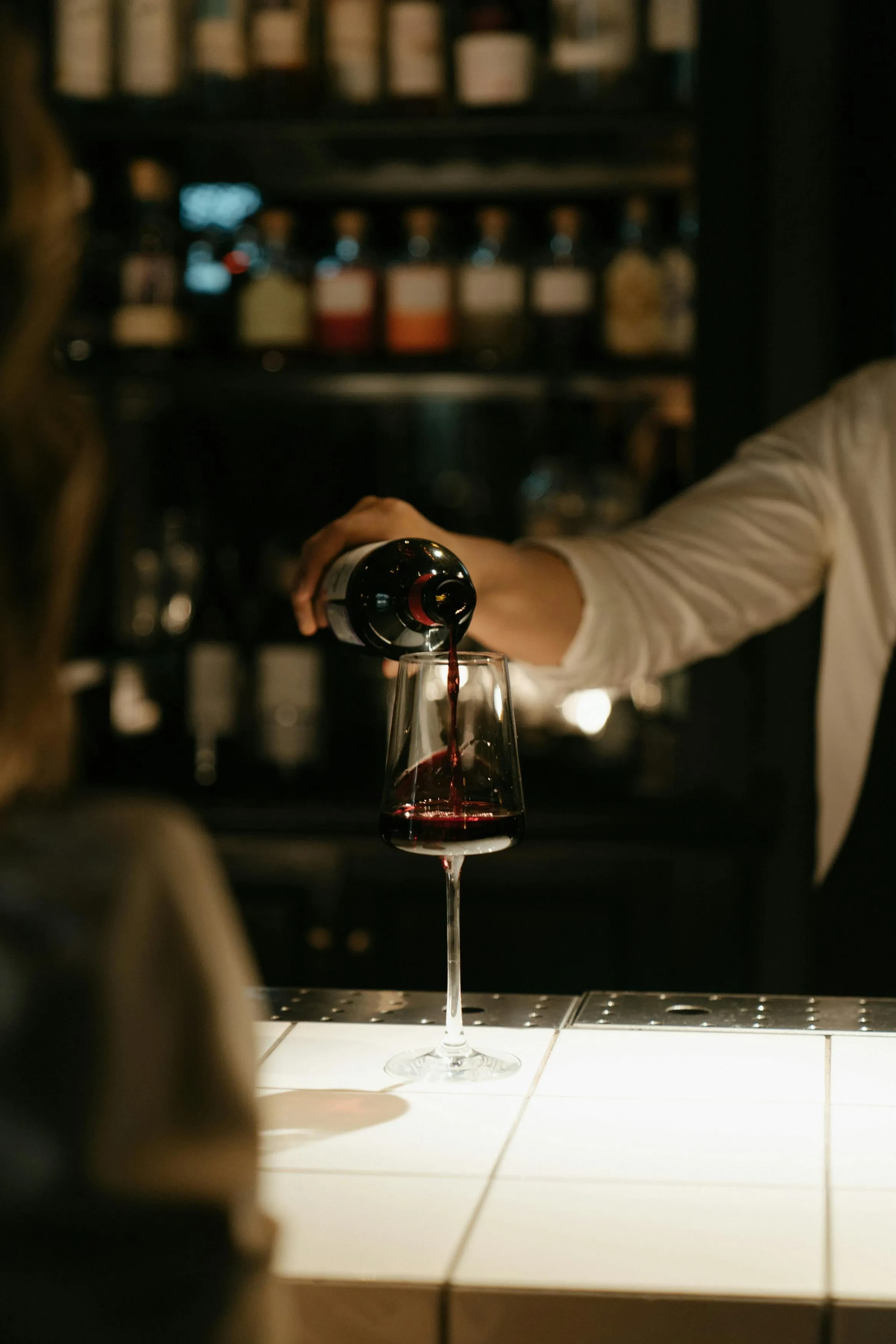 Serveur versant du vin rouge dans un verre