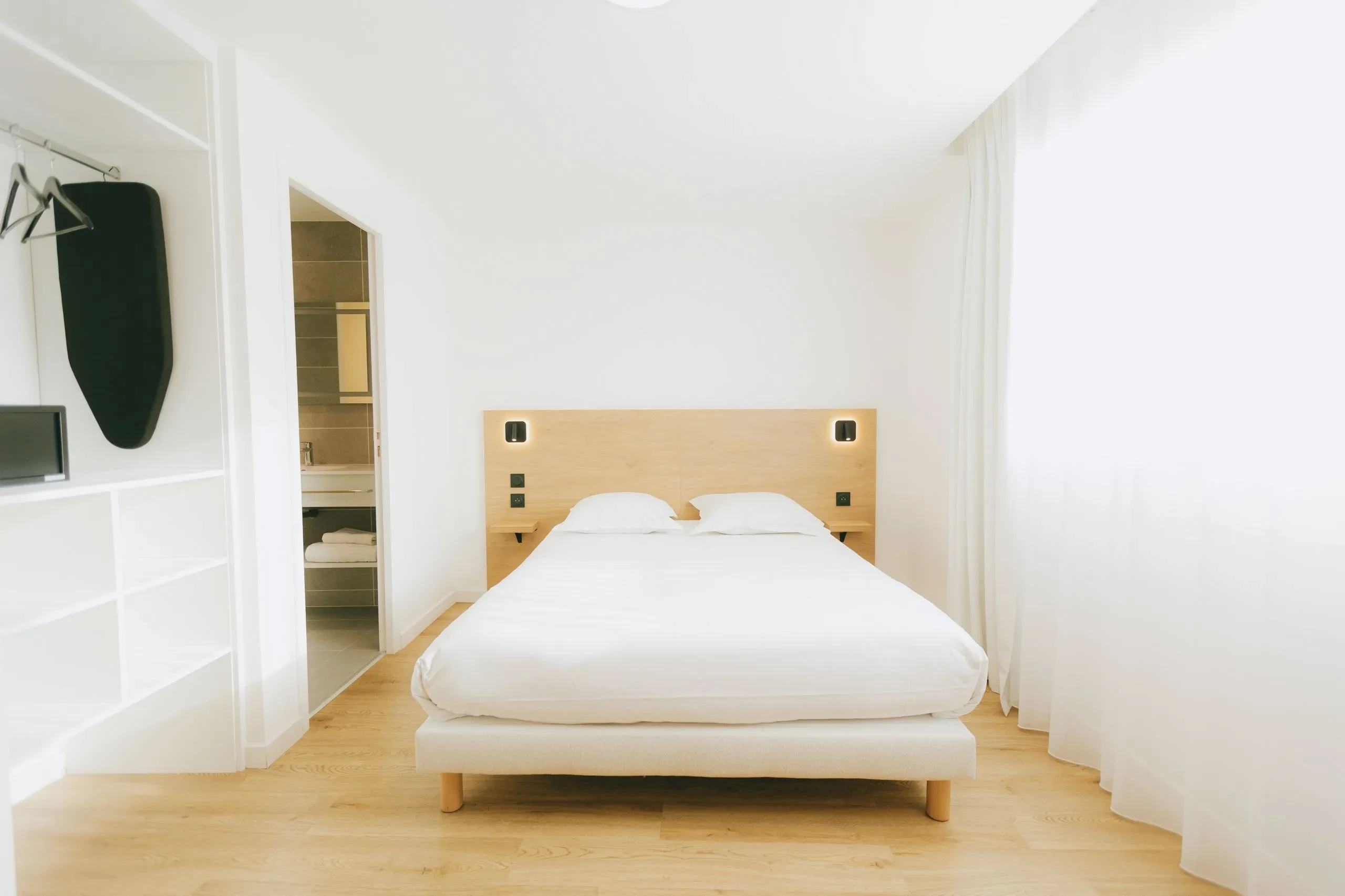 Chambre d'hôtel lumineuse avec lit double.