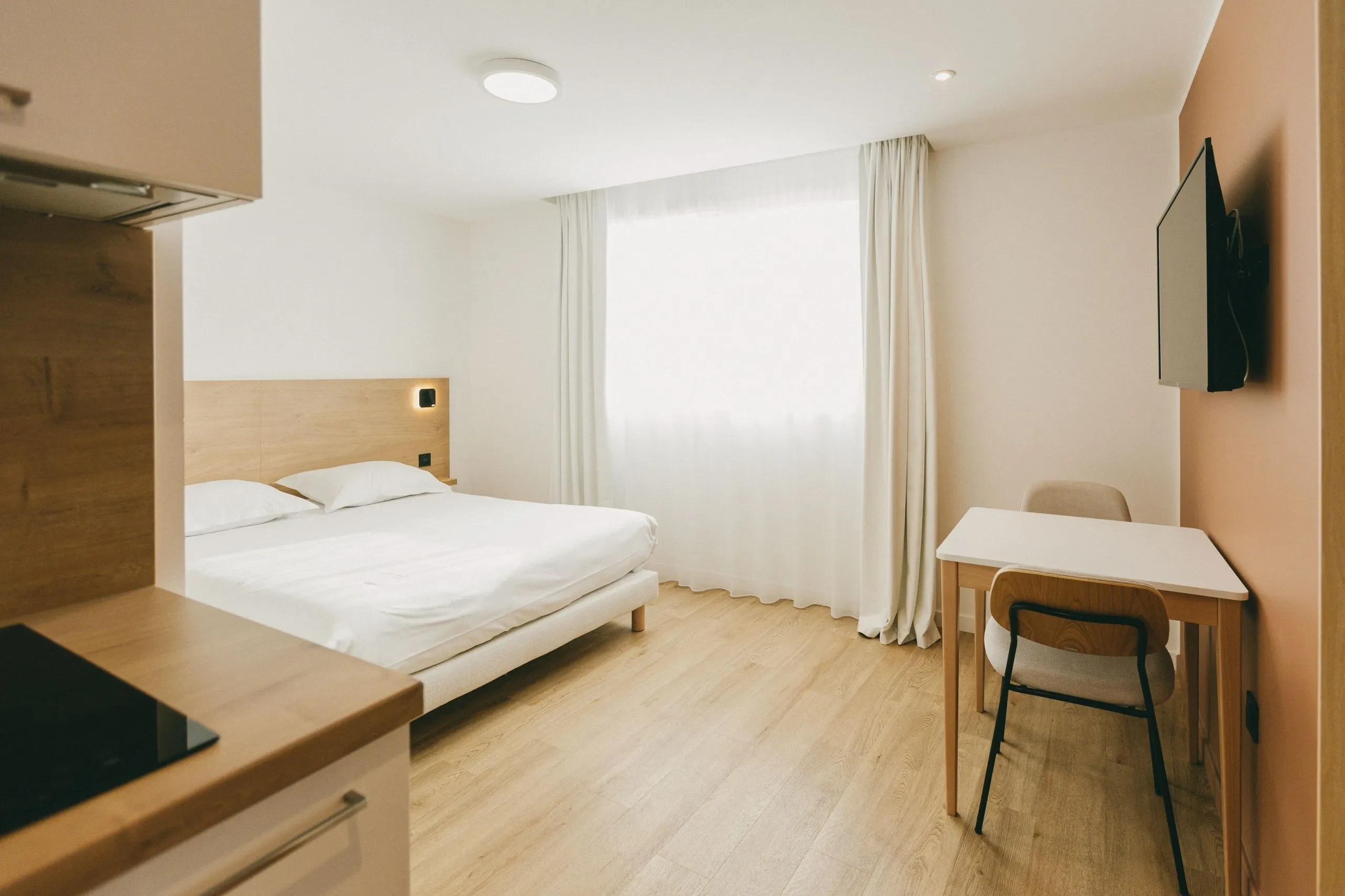 Chambre d'hôtel moderne avec lit et bureau.