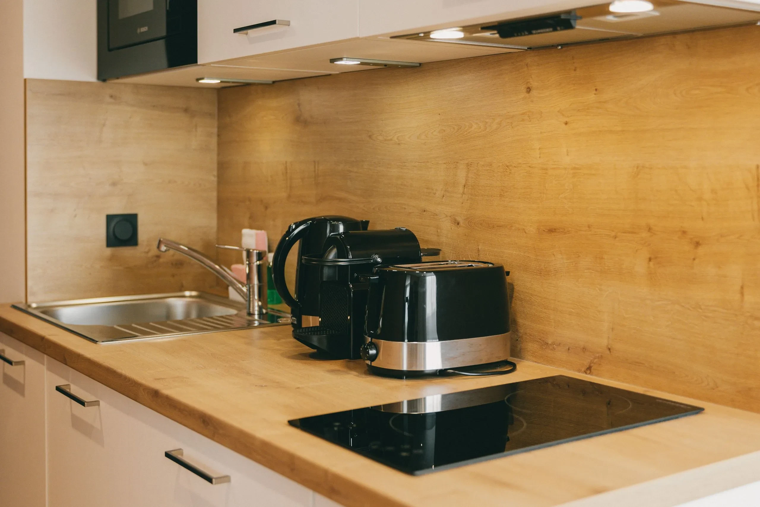 Cuisine moderne avec appareils électroménagers noirs.