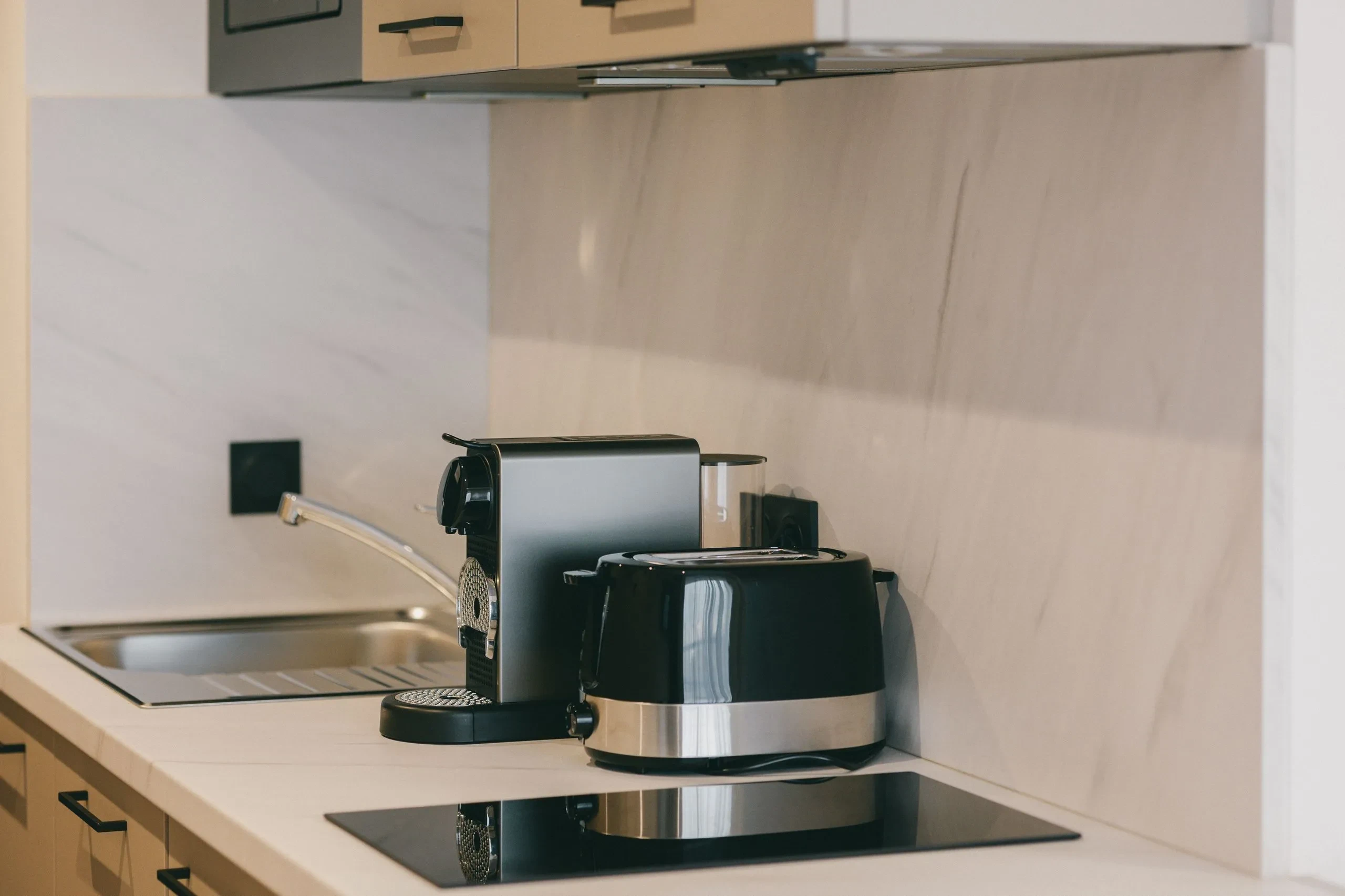 Cuisine moderne avec cafetière et grille-pain noirs.