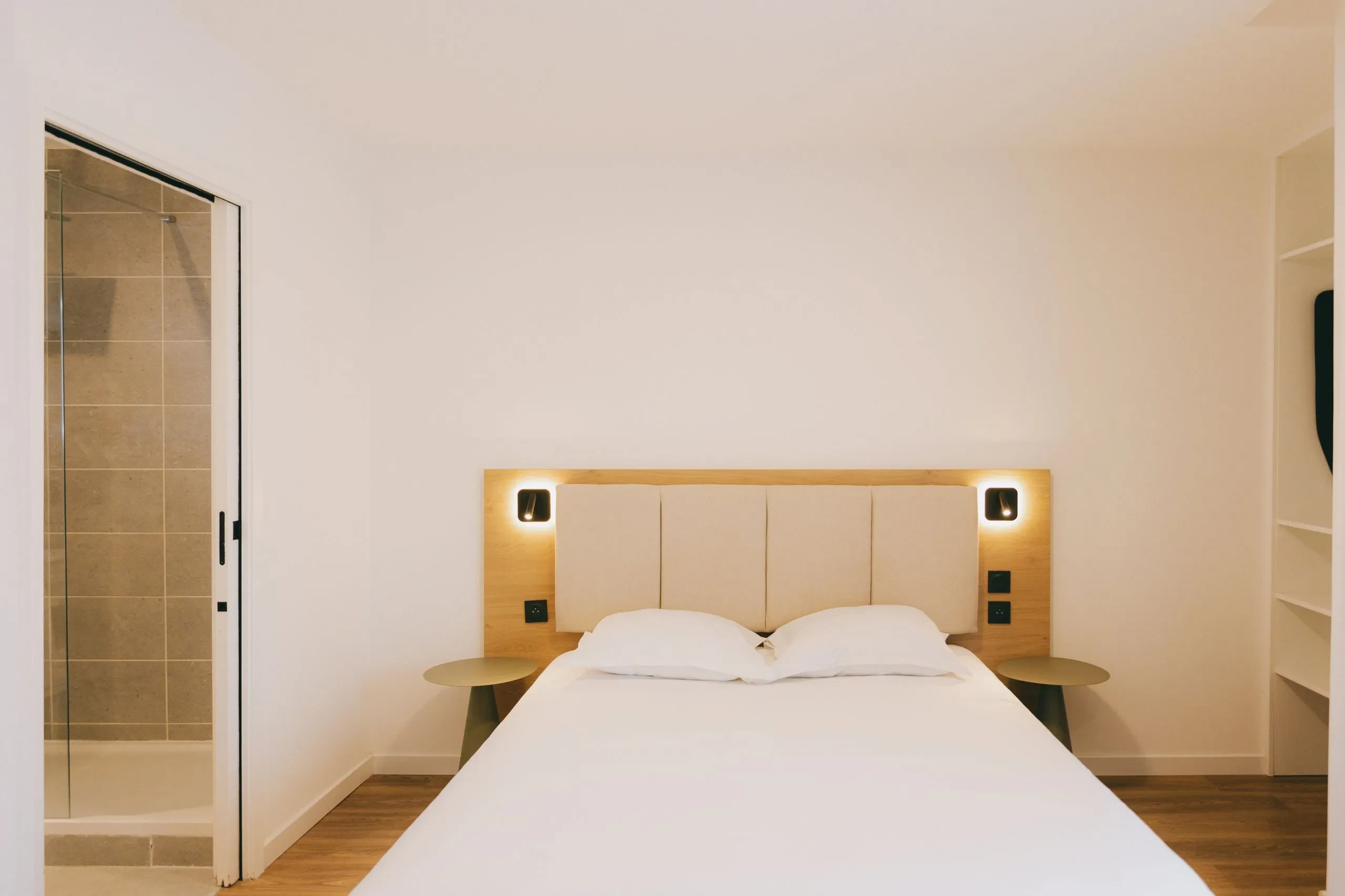 Chambre d'hôtel moderne avec salle de bain attenante.